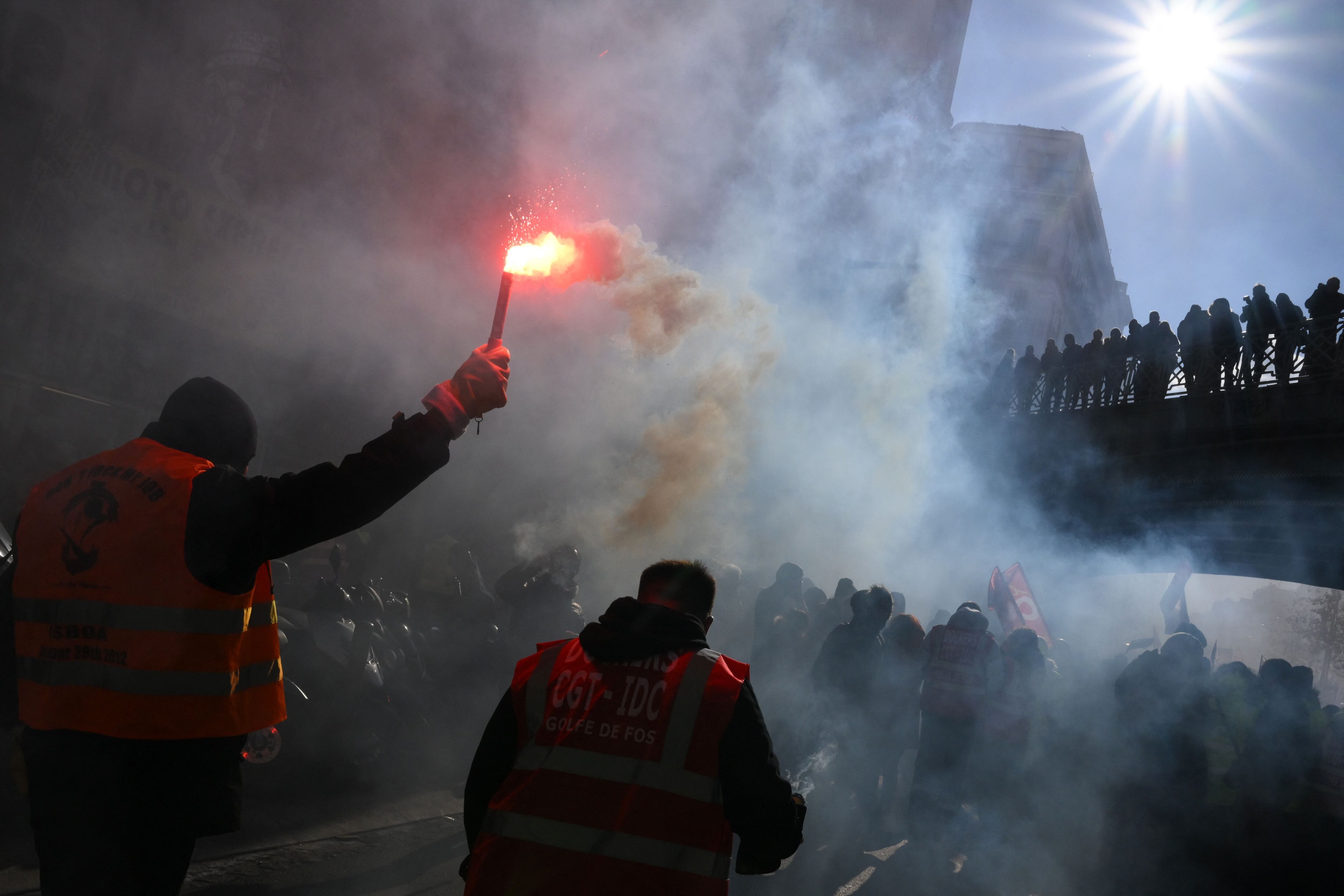 A protester waves a sparkler during a demonstration called by French unions against the government's pension reform plan in Marseille, southern France, on January 19, 2023. - On January 19, 2023, a protest began in France. day of strikes and protests.  disrupt transportation and education across the country in a lawsuit for the government, as workers oppose a deeply unpopular pension reform.  (Photo by NICOLÁS TUCAT / AFP)