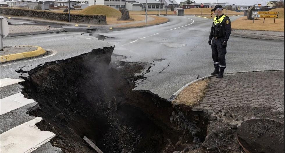 Un oficial de policía está junto a la grieta en una carretera en el pueblo pesquero de Grindavik, Islandia, que fue evacuado debido a la actividad volcánica y los terremotos, el 15 de noviembre de 2023. (REUTERS/Marko Djurica).