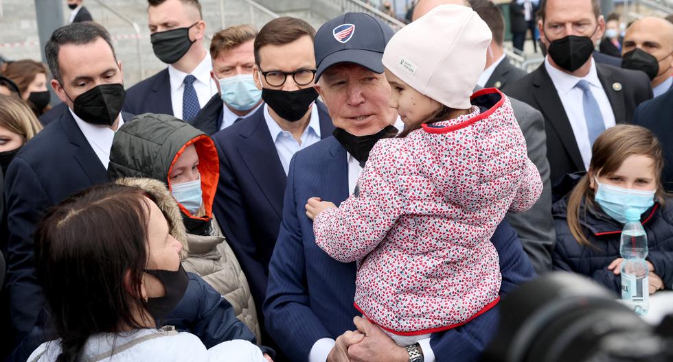 El presidente de Estados Unidos, Joe Biden, carga a una niña ucraniana refugiada, en Varsovia, Polonia. REUTERS