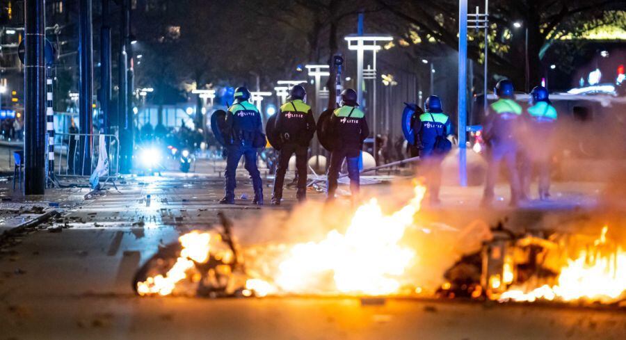 Policemen next to burning objects after a protest against '2G politics' escalated into riots, with protesters setting the street on fire and destroying police cars and street furniture, Rotterdam, The Netherlands.  (EFE / EPA / VLN NIEUWS).