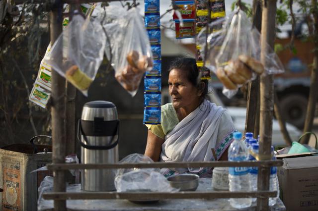 Una mujer espera a los clientes en su puesto de té al lado de la calle en Gauhati (India), el 7 de marzo. (Foto: AP)