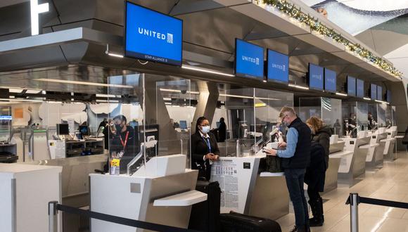 Los viajeros se registran en el aeropuerto LaGuardia en Nueva York, el 24 de diciembre de 2021. (Yuki IWAMURA / AFP).