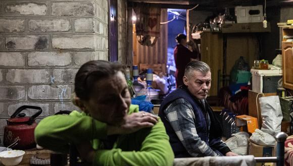 Los residentes locales descansan mientras se reúnen en un sótano donde viven familias para buscar más protección debido al intenso bombardeo de las fuerzas rusas en la ciudad de Bakhmut, en el este de Ucrania, el 21 de diciembre de 2022. (Foto: Sameer Al-DOUMY / AFP)