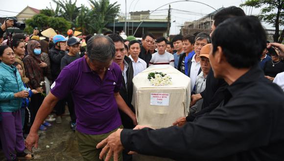 Una multitud observa a los familiares que llevan el ataúd de Nguyen Van Hung, mientras llega al distrito de Dien Chau, provincia de Nghe An, después de ser repatriado de Gran Bretaña. (AFP)