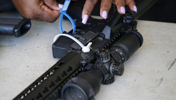 Una oficial de policía de la ciudad de Miami etiqueta un rifle AR-15 durante un evento de recompra de armas. (Foto referencial, RHONA WISE / AFP).