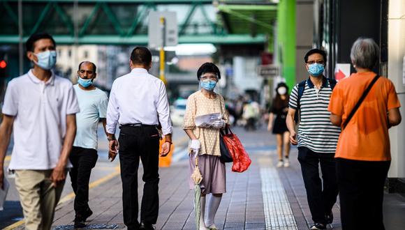 Los peatones usan máscaras faciales en el distrito Sham Shui Po, de Kowloon, en Hong Kong, a medida que entran en vigencia nuevas medidas de distanciamiento social que incluyen el uso de máscaras en público para combatir una nueva ola de coronavirus. (ANTHONY WALLACE / AFP)