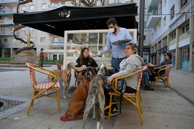 Un camarero atiende a los clientes en un café en Tarragona el 11 de mayo de 2020, mientras España alivia su estricto bloqueo en ciertas regiones. (Foto: AFP/Lluis Gene)