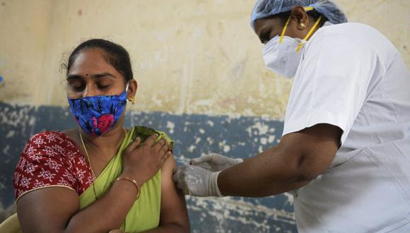 Personal sanitario inocula a una mujer con una dosis de la vacuna Covishield contra el coronavirus Covid-19 en Hyderabad, India, el 28 de mayo de 2021. (Foto de NOAH SEELAM / AFP).