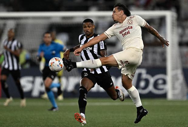 Botafogo's forward Junior Santos (L) and Universitario's Paraguayan defender Williams Riveros fight for the ball during the Copa Libertadores group stage first leg football match between Brazil's Botafogo and Peru's Universitario at the Nilton Santos Stadium in Rio de Janeiro, Brazil, on April 24, 2024. (Photo by MAURO PIMENTEL / AFP)