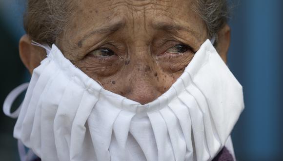 Con lágrimas en los ojos, una devota observa una estatua de Jesús durante las celebraciones de la Semana Santa en Caracas, Venezuela, el miércoles 8 de abril de 2020. Lleva una mascarilla hecha en casa. (Foto: AP /Ariana Cubillos)