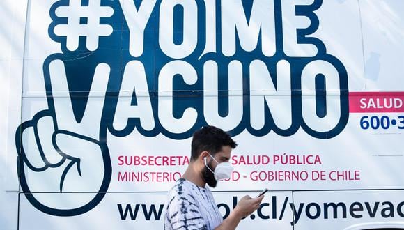Un hombre camina frente a un bus de vacunación contra el coronavirus en Santiago de Chile. (EFE/Alberto Valdés).