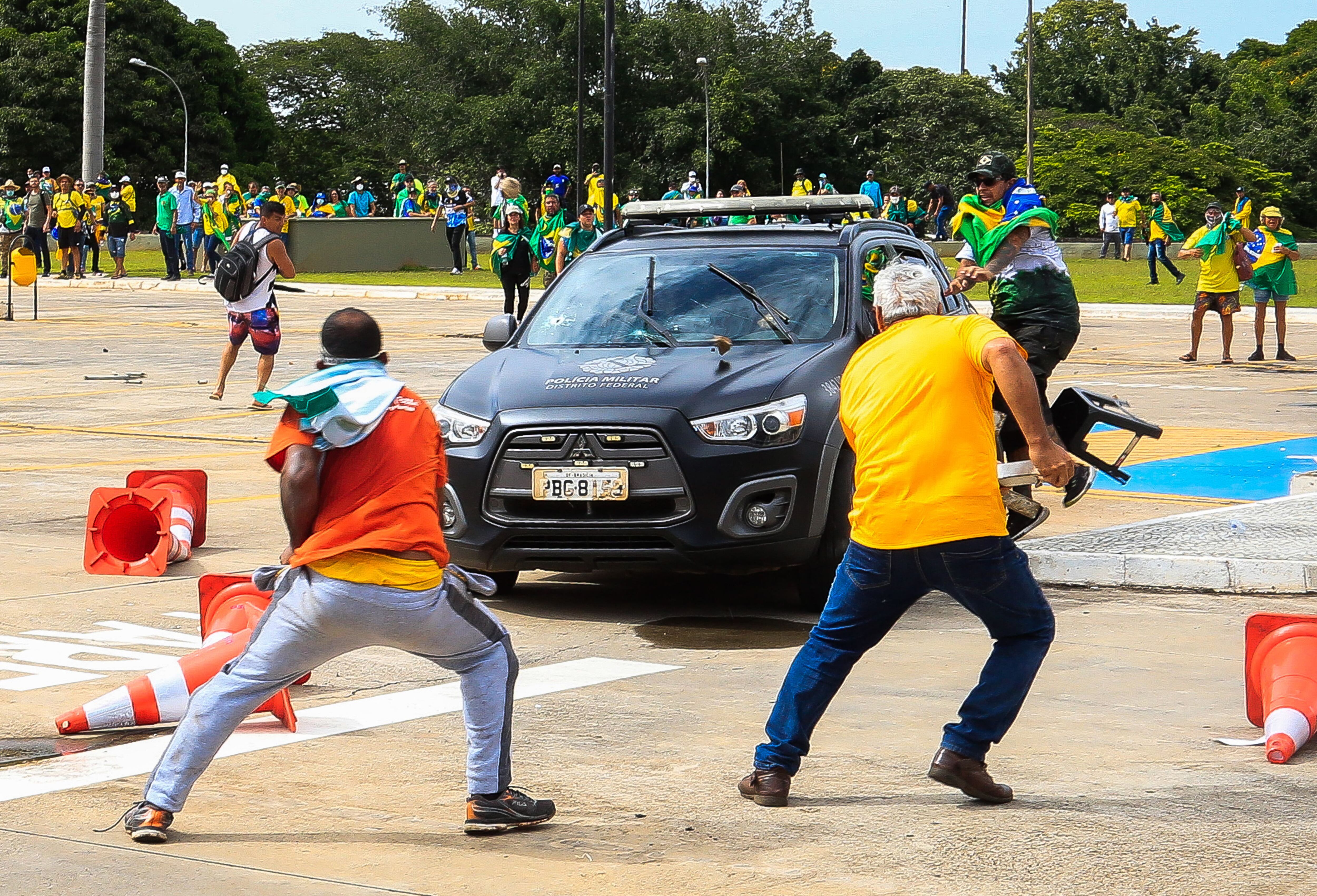 Supporters of Jair Bolsonaro attack a Military Police vehicle during clashes in front of the Planalto Palace, in Brasília, on January 8, 2023. (Photo by Sergio Lima/AFP).