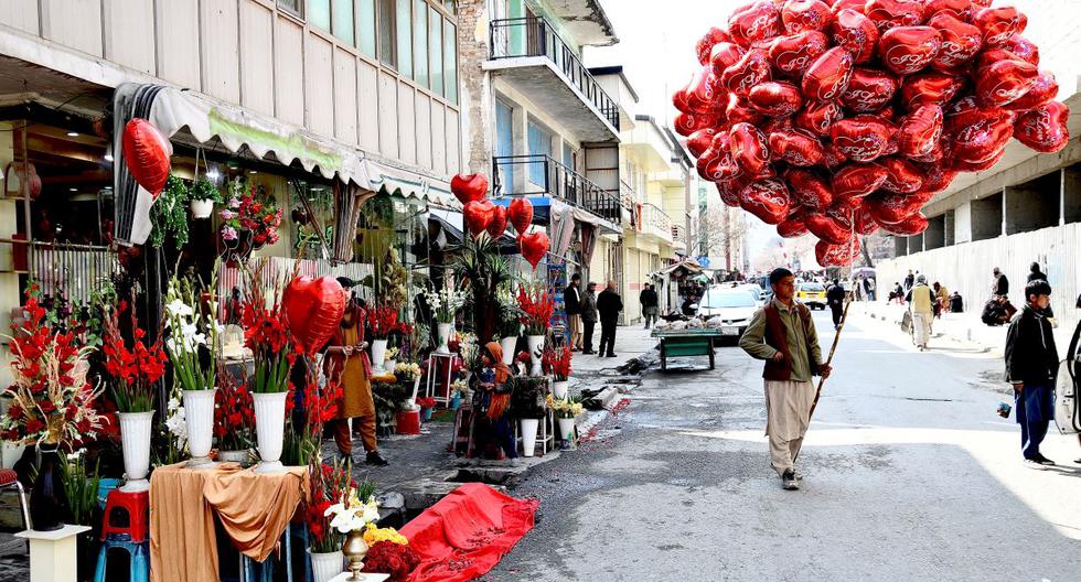 Un vendedor ambulante lleva globos en forma de corazón mientras espera a los clientes en el Día de San Valentín en Kabul, Afganistán, el 14 de febrero de 2022. (Ahmad SAHEL ARMAN / AFP).