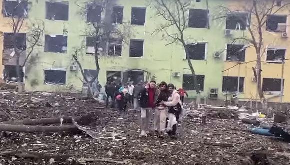 Las personas son ayudadas a salir de un hospital infantil dañado por los bombardeos de Rusia en la ciudad de Mariupol. (AFP).