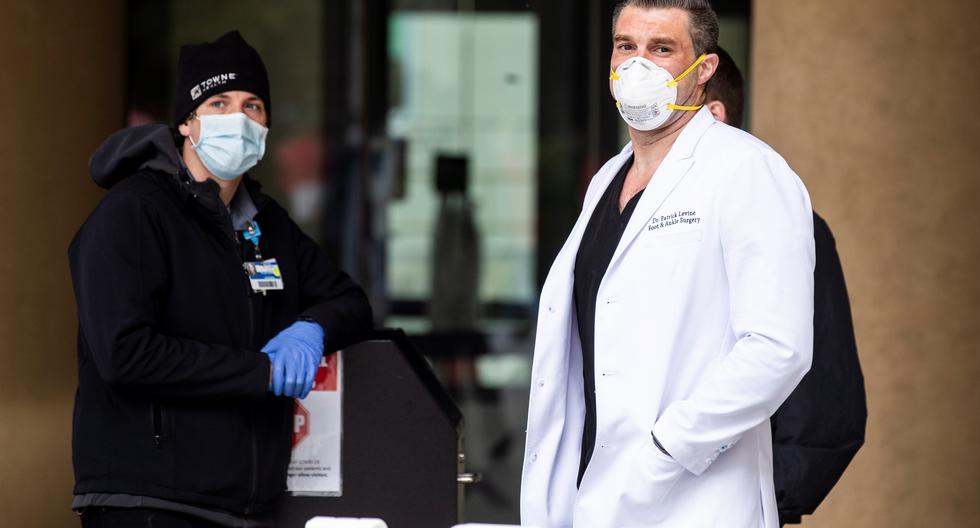 Un médico y personal médico con máscaras faciales se encuentran afuera del Hospital Saint Joseph en medio de la actual pandemia de coronavirus, en Burbank, California, EE. UU. (Foto: EFE)