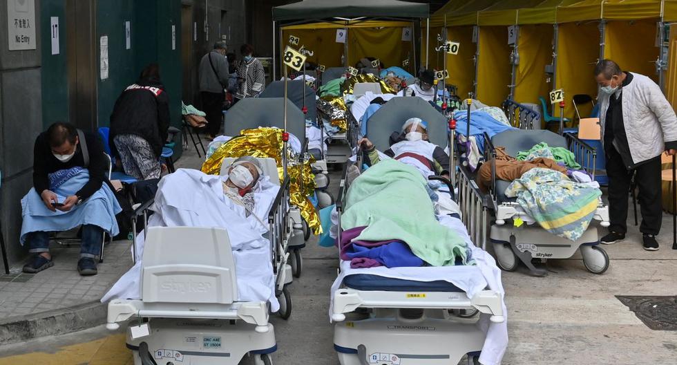 Las personas permanecen en camillas afuera del Centro Médico Caritas en Hong Kong el 15 de febrero de 2022, mientras la ciudad enfrenta su peor ola de coronavirus covid-19. (Pedro PARQUES / AFP).