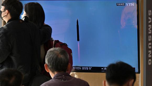 La gente mira un televisor que muestra una transmisión de noticias con imágenes de archivo de una prueba de misiles de Corea del Norte, en una estación de tren en Seúl el 17 de noviembre de 2022. (Foto de Anthony WALLACE / AFP)