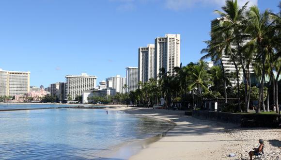 Un hombre se sienta en la playa de Waikiki en Honolulu. (Foto: AP / Caleb Jones, Archivo).