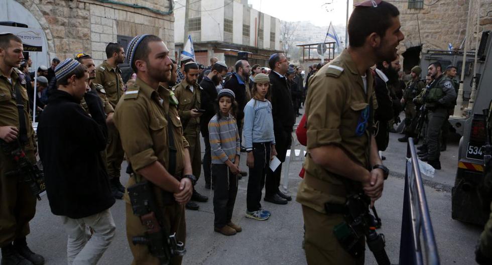 Soldados y colonos israelíes rezan en calle de Hebrón. (Foto: EFE)
