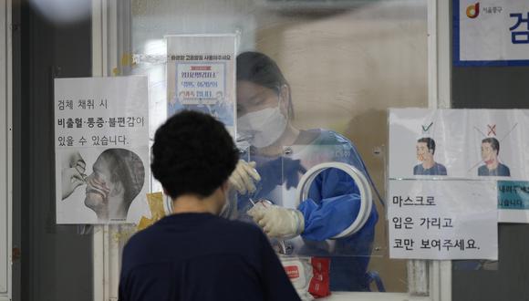 Un trabajador médico en una cabina se prepara para tomar muestras en una clínica de detección temporal del coronavirus en el centro de Seúl, Corea del Sur.
