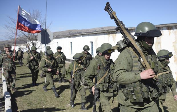 In this 2014 photo, a Russian flag accompanies Russian soldiers deployed to the Crimean peninsula, which was annexed to Russia after a referendum. AFP PHOTO / ALEXANDER NEMENOV