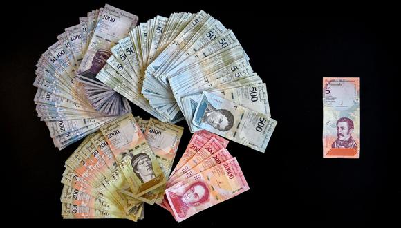 Un billete de los nuevos 5 bolívares soberanos y su equivalente en billetes antiguos. (AFP).
