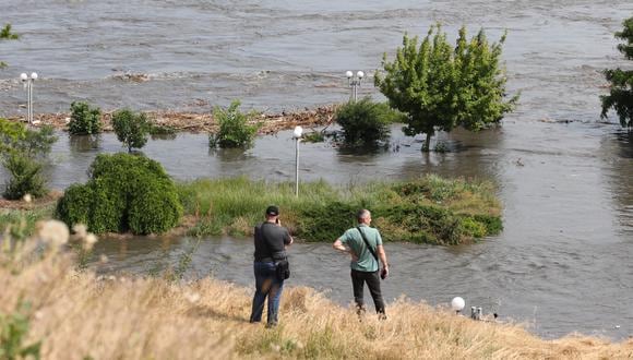 Los residentes locales observan un área parcialmente inundada de Kherson el 6 de junio de 2023, luego de los daños sufridos en la represa Kakhovka HPP. (Foto de STRINGER / AFP)
