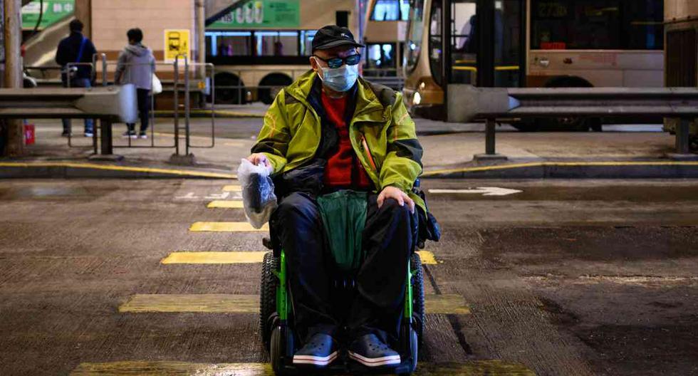El paciente Steven Yan en su silla de ruedas después de bajar de un bus en su camino a comprar mascarillas para protegerse del coronavirus en Sheung Shui, Hong Kong. (Foto: PHILIP FONG / AFP)