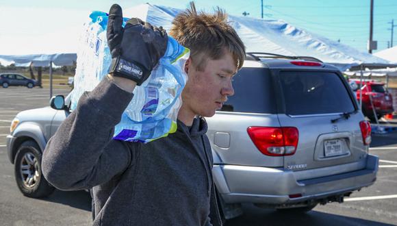 Un hombre recoge botellas de agua donada en Galveston, Texas. (Thomas Shea / AFP).