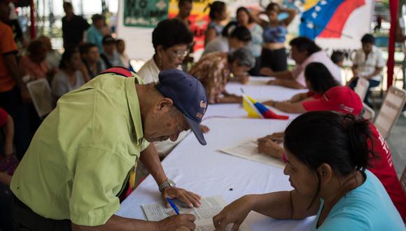 La colecta se realizó en las céntricas plazas Bolívar de varias ciudades del país, incluida la de la capital Caracas, donde centenares de militantes hicieron fila para estampar su rúbrica. (AFP)