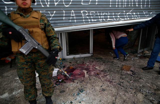 Militares resguardan un negocio saqueado en Santiago de Chile. (AFP / Pablo VERA).
