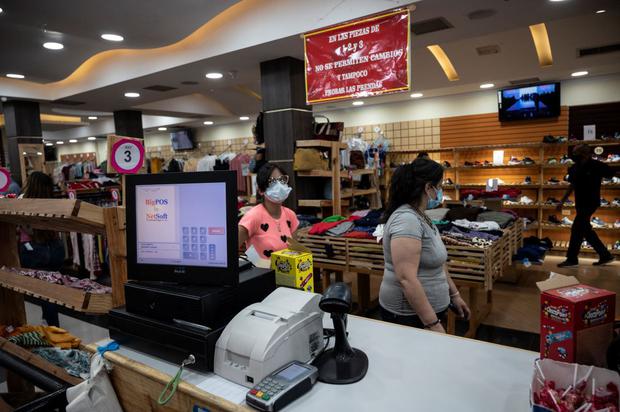 Women buy clothes in a store priced in dollars in Caracas on September 21, 2021. (YURI CORTEZ / AFP).