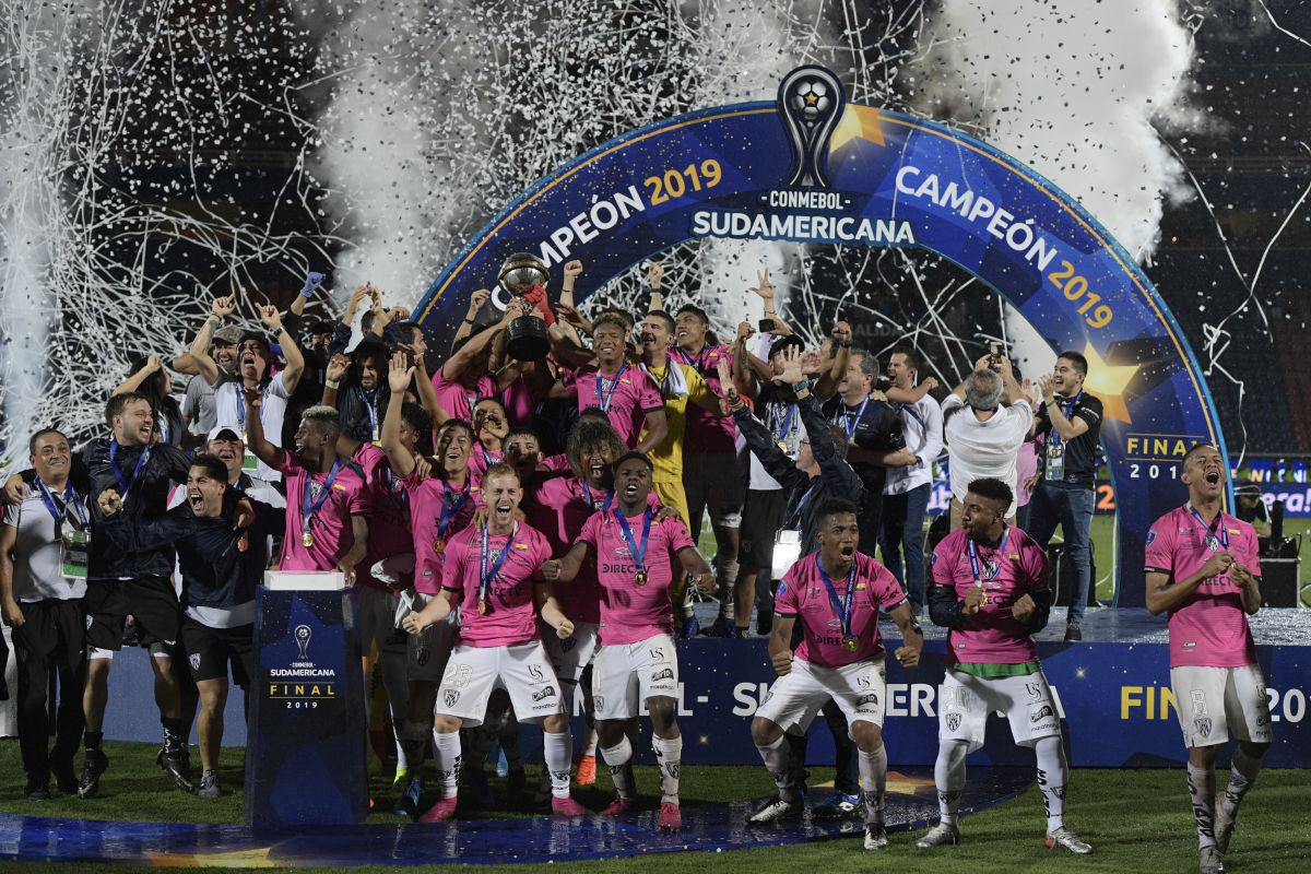 Players of Ecuador's Independiente del Valle celebrate on the podium with the trophy after winning the Copa Sudamericana final football match by defeating Argentina's Colon de Santa Fe, at the General Pablo Rojas stadium in Asuncion, on November 9, 2019. (Photo by Juan Mabromata / AFP)