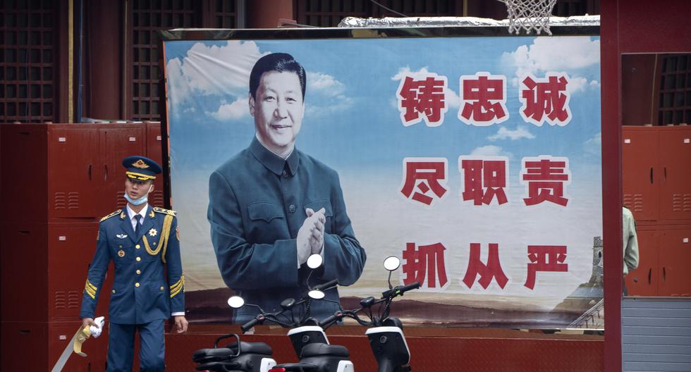 Un miembro de la guardia real china camina por las calles de Beijín. Detrás suyo, una imagen propagandística a favor de Xi. AP