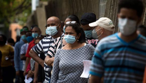 Personas con mascarillas hacen cola para tomar una prueba de PCR que detecta el nuevo coronavirus, COVID-19, en Santo Domingo. (Foto: AFP / Erika SANTELICES).