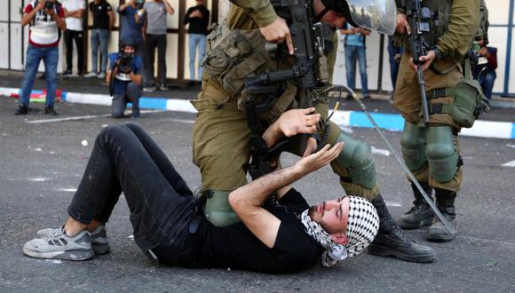 Soldados israelíes arrestan a un hombre palestino durante enfrentamientos tras una protesta en el centro de la ciudad de Hebrón, Cisjordania, el 20 de octubre de 2022. (Foto de EFE/EPA/ABED AL HASHLAMOUN)