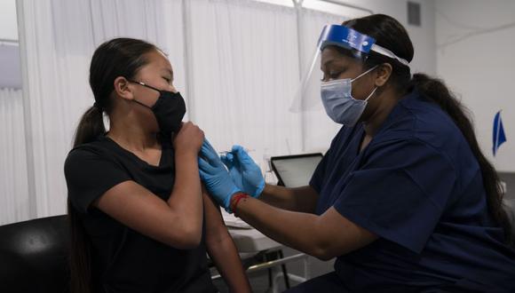 Payton Nguyen, de 12 años, recibe la vacuna Pfizer COVID-19 de la enfermera Lakera Thorne en el sitio de vacunación de Providence Edwards Lifesciences en Santa Ana, California. (Foto:  AP / Jae C. Hong)