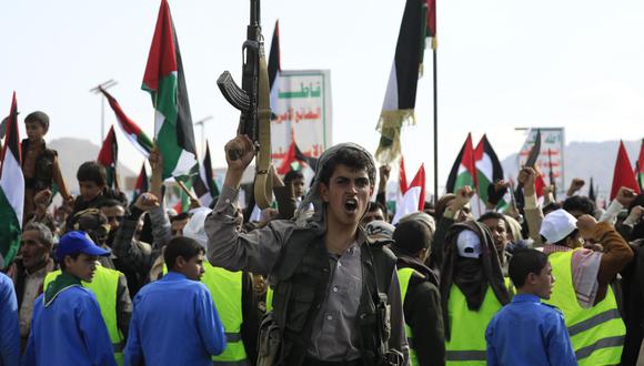 Un rebelde hutí grita consignas y sostiene un arma durante una protesta contra una operación multinacional para salvaguardar el transporte marítimo del Mar Rojo y en solidaridad con el pueblo palestino, en Saná, Yemen. (EFE/EPA/YAHYA ARHAB).