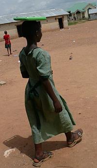 Una niña en Nigeria camina por el pueblo con su computadora. 2007.