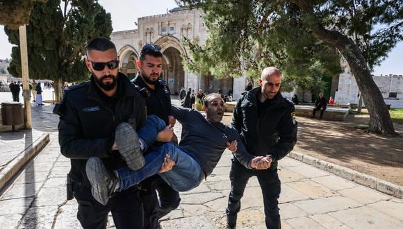 Policías israelíes detienen a un hombre palestino en el complejo de la mezquita de Al-Aqsa luego de los enfrentamientos que estallaron durante el mes sagrado islámico de ayuno del Ramadán en Jerusalén el 5 de abril de 2023. - La policía israelí arrestó a más de 350 personas a principios del 5 de abril, luego de los enfrentamientos en el punto crítico de Jerusalén. Mezquita Al-Aqsa, dijo un portavoz de la policía. (Foto de Ahmad GHARABLI / AFP)