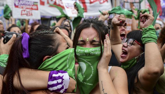 Manifestantes celebran con pañuelos verdes en la cabeza, el símbolo de los activistas por el derecho al aborto, frente al Congreso de Argentina el 11 de diciembre de 2020. (Foto de RONALDO SCHEMIDT / AFP).