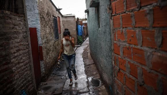 Una mujer camina por una calle de la villa Puerta 8, donde se vendió la cocaína adulterada que ya causo 20 muertos y 70 personas hospitalizadas en Buenos Aires, Argentina. (EFE/ Juan Ignacio Roncoroni).