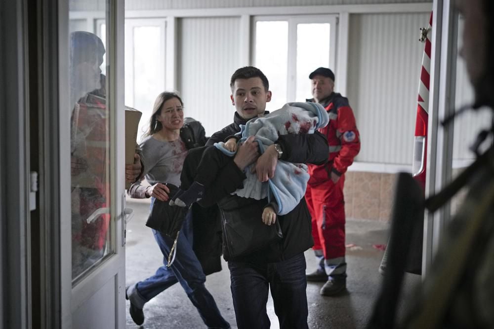 Marina Yatsko, left, runs after her boyfriend Fedor with their 18-month-old son Kirill, who was killed in a shelling, as they arrive at a hospital in Mariupol, Ukraine, Friday, March 4, 2022. (Photo: AP /Evgeny Maloletka)