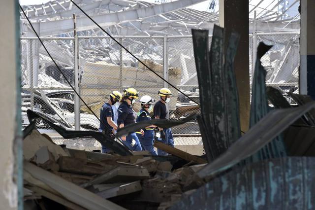 Miembros de la Agencia Federal Alemana de Ayuda Técnica (THW) buscan cuerpos y sobrevivientes entre los escombros tres días después de las explosiones que golpearon el puerto de Beirut, Líbano. (EFE/EPA/WAEL HAMZEH).