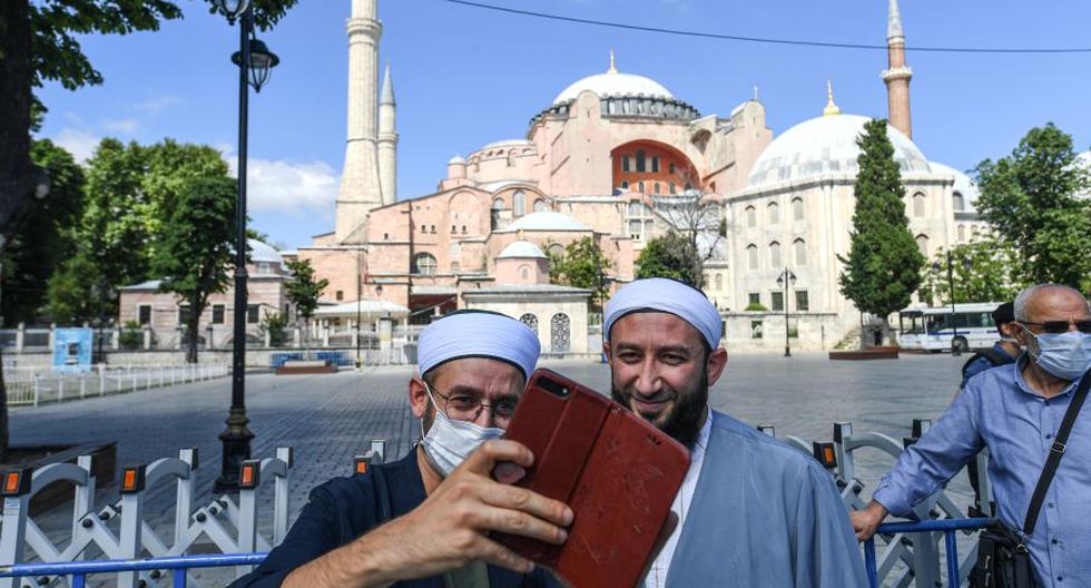 Dos hombres se tomaron una selfie frente a Santa Sofía el 11 de julio de 2020 en Estambul, un día después de que un tribunal turco decidiera que sea convertida en mezquita. (Foto por Ozan KOSE / AFP).