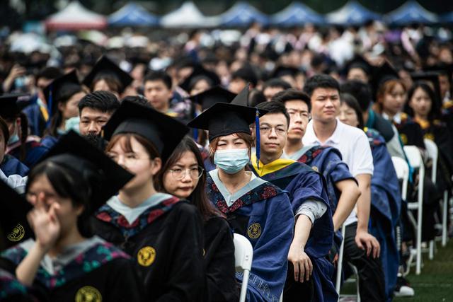 Unos 11.000 graduados, incluidos más de 2.000 estudiantes que no pudieron asistir a la ceremonia del año pasado debido al brote de coronavirus Covid-19, asisten a una ceremonia en la Universidad Normal de China Central en Wuhan. (Foto de STR / AFP).