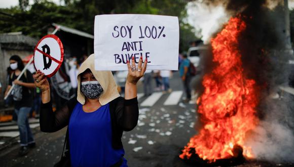 Cientos de personas manifestaron contra el Bitcoin en el entorno de la Asamblea Legislativa de San Salvador y quemaron neumáticos mientras eran vigilados por la policía antimotines. (Foto: Jose Cabezas / Reuters)