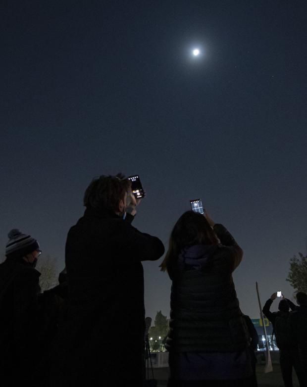 Ludzie robią zdjęcia całkowitego zaćmienia Księżyca w Santiago, Chile, 15 maja 2022 r. (MARTIN BERNETTI / AFP).