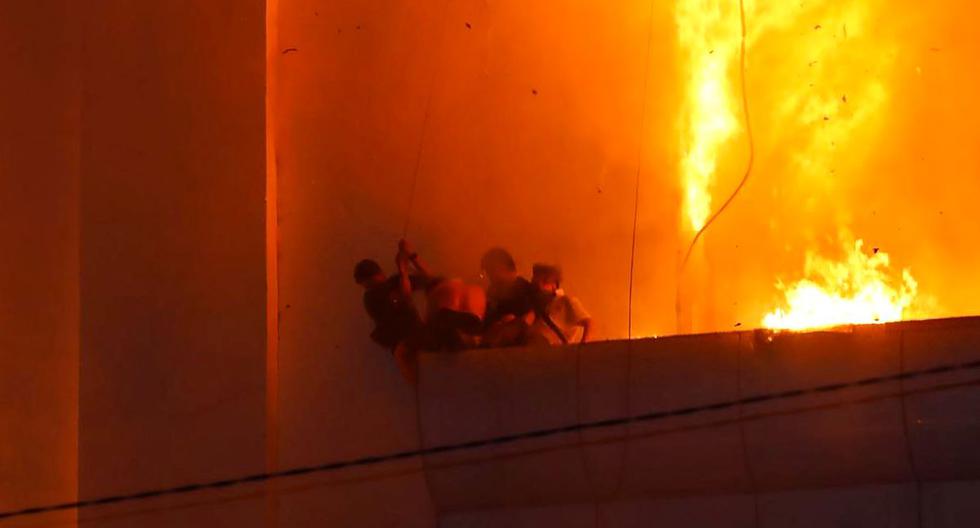 Las personas tratan de escapar del fuego mientras se incendia el hotel-casino Grand Diamond City en Poipet, Camboya, el 29 de diciembre de 2022. (AFP).