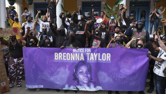 Los manifestantes posan para una foto frente a un restaurante local en Kentucky,  en el tercer día de protesta por la falta de cargos penales en el asesinato policial de Breonna Taylor, el 25 de septiembre de 2020. (Foto: Jeff Dean / AFP)